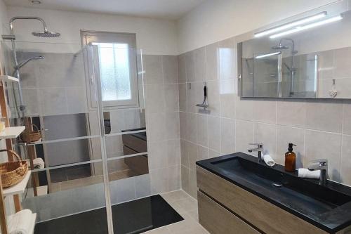 a bathroom with a black sink and a shower at Pavillon 3 chambres avec piscine, Garat (16) in Garat