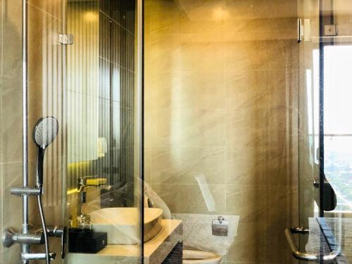 a bathroom with a sink and a glass shower at Apec Mandala hotel & suites Hải dương in Hải Dương