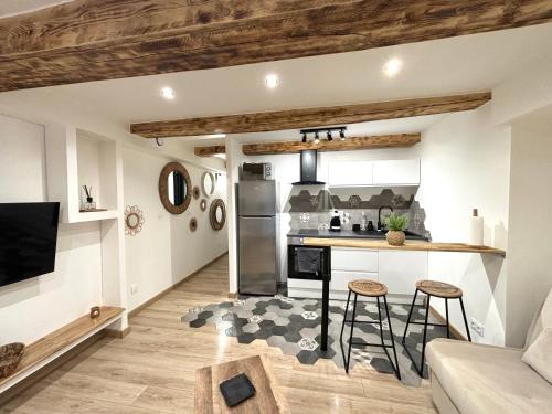 - une cuisine et un salon avec un comptoir et des tabourets dans l'établissement Studio au cœur de la Venise provençale, à Martigues