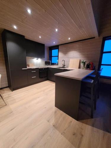 a large kitchen with a island in the middle at Flott enderekkehus med fantastisk utsikt in Longyearbyen