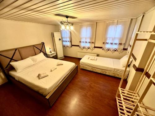 um quarto com 2 camas e 2 janelas em Melkan Otel Guest House em Istambul