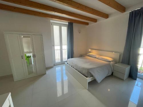 een witte slaapkamer met een bed en een raam bij Palazzo di Fazio Suites in San Severo
