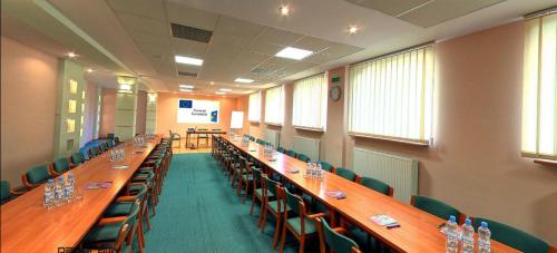 duża sala konferencyjna z długimi drewnianymi stołami i krzesłami w obiekcie Hotel SONATA w mieście Duszniki Zdrój