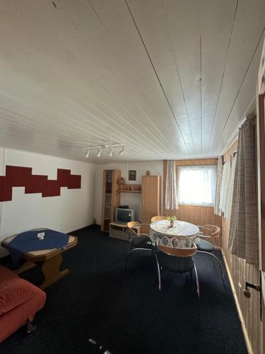 Zimmer mit einem Tisch und Stühlen sowie einer Küche in der Unterkunft Feriendorf Finnhütte in Niesky