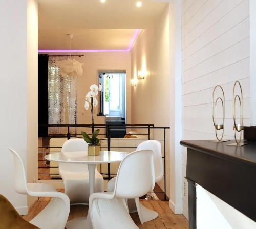 a dining room with a white table and white chairs at Spacieux 90m2 Jacuzzi, Standing,Bien-être in Toulouse