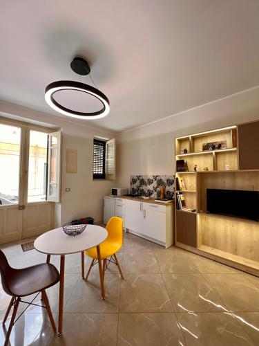 ein Wohnzimmer mit einem Tisch und Stühlen sowie eine Küche in der Unterkunft Casa Dom-Ino 25 in Bagheria