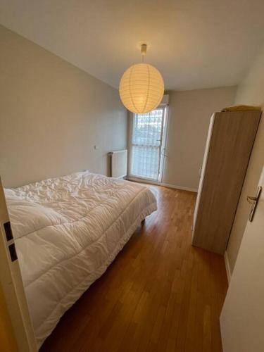 um quarto com uma cama e uma grande janela em Logement entier : appartement ⸱ Chez Slimane em Massy