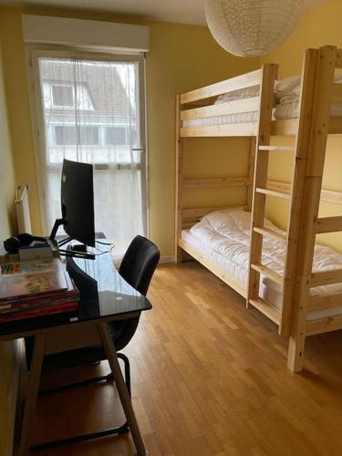 Logement entier : appartement ⸱ Chez Slimane في ماسي: غرفة مع مكتب مع جهاز كمبيوتر وسرير بطابقين