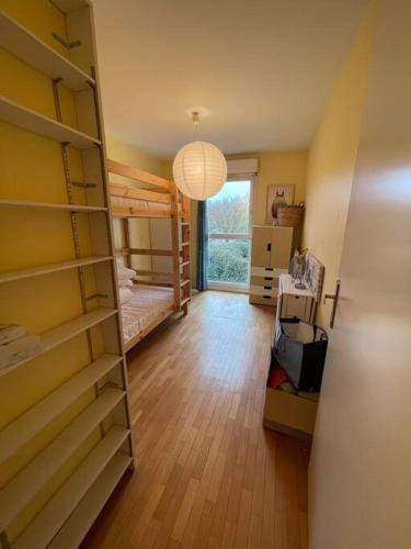 um quarto com um beliche e uma grande janela em Logement entier : appartement ⸱ Chez Slimane em Massy