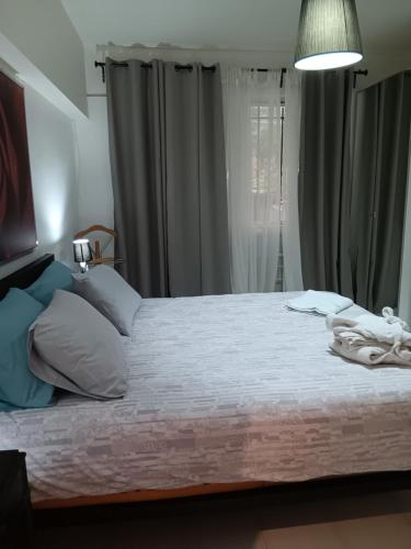a bedroom with a large bed with gray curtains at Erato in Athens