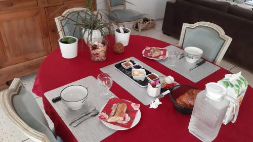 een tafel met een rode tafeldoek met eten erop bij 1 Chambre double "Le Devenir" in Saint-Julien-les-Villas