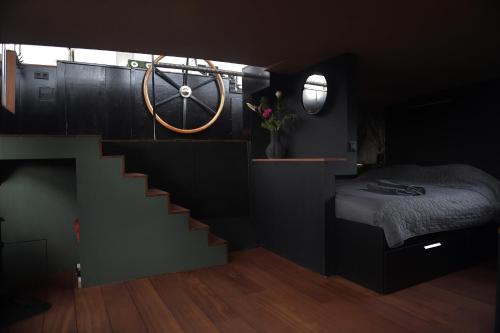 a bedroom with a staircase leading up to a bed at WHEELHOUSE EUPHRATE HOUSEBOAT in Amsterdam