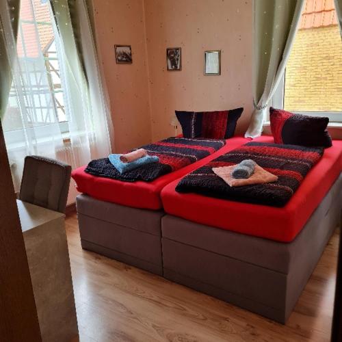 a large bed in a room with two people on it at Wilhelm Busch Stube in Ebergötzen