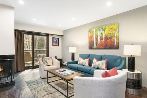 een woonkamer met een blauwe bank en stoelen bij 303 Fallridge Condominiums condo in Vail