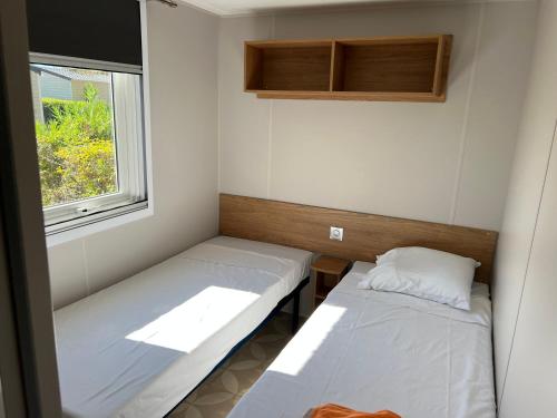 a small room with two beds and a window at JP - L'Eleganzia 2 ch, clim réversible, Confort et Elégance, in Lattes