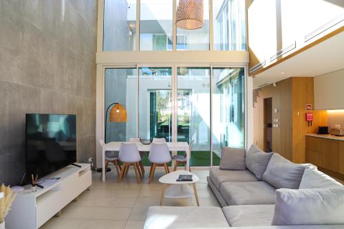 a living room with a couch and a tv at Villa Central By Garvetur in Quarteira