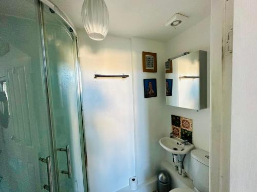 uma casa de banho com um chuveiro e um lavatório. em Fitz House em Keswick