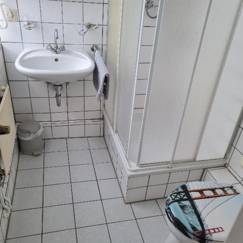 a white bathroom with a sink and a toilet at Wilhelm Busch Stube in Ebergötzen
