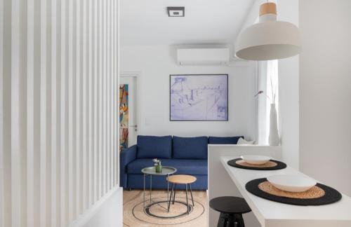 uma sala de estar com um sofá azul e uma mesa em Alyvia Central Apartment 2 em Ioannina