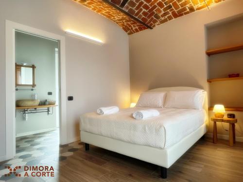a bedroom with a white bed with two towels at Dimora a Corte in Mathi