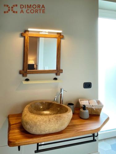 a bathroom with a large stone sink on a wooden counter at Dimora a Corte in Mathi