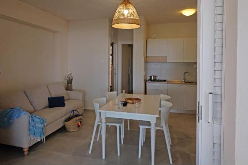 a living room and kitchen with a table and a couch at Baia Degli Aranci Suite & Apartments in Vieste