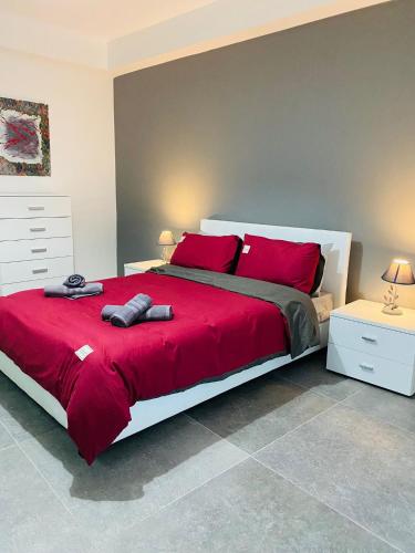ein Schlafzimmer mit einem großen roten Bett mit roten Kissen in der Unterkunft Sliema Seaview Apartment- Valletta Views - APT 8, 49 Tigne Point Mansions in Sliema
