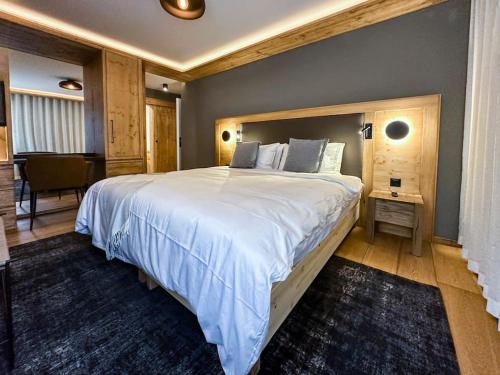 a large bedroom with a large bed and a table at Chic Alpine Elegance: Designer Retreat in Samedan in Samedan