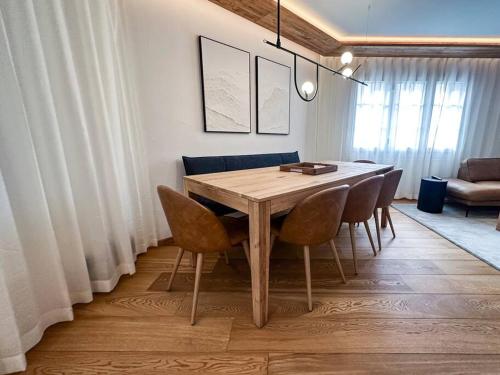 a dining room with a wooden table and chairs at Chic Alpine Elegance: Designer Retreat in Samedan in Samedan