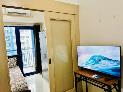 a living room with a flat screen tv on a table at Sea Residences - Angel Alano in Manila