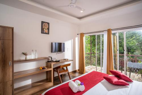1 dormitorio con cama, escritorio y ventana en Wild Poetry, en Munnar