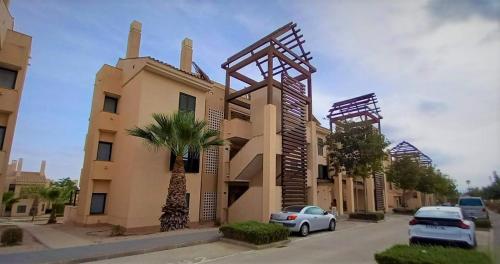 ein Gebäude mit davor geparkten Autos in der Unterkunft Casa Martinica 12-1-A , Hacienda del Alamo in Murcia