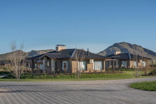 a row of houses with mountains in the background at Los Alerces Resort, Hotel & Spa in San Andres de las Sierras