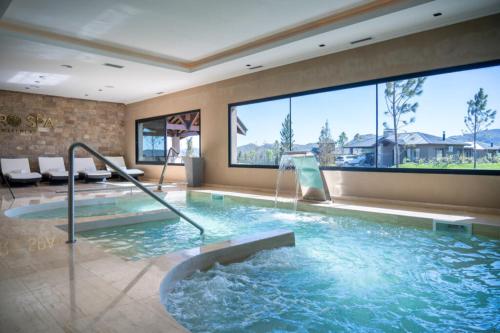 a large swimming pool with a water fountain at Los Alerces Resort, Hotel & Spa in San Andres de las Sierras