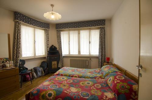 コルティーナ・ダンペッツォにあるAccogliente appartamento in Corso Italiaのベッドルーム1室(カラフルな毛布付きのベッド1台付)
