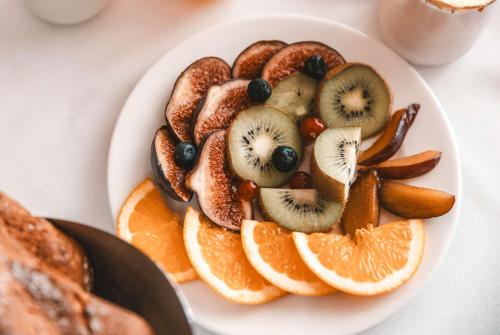 a plate of fruit and nuts on a table at Les Violettes Hotel & Spa in Jungholtz