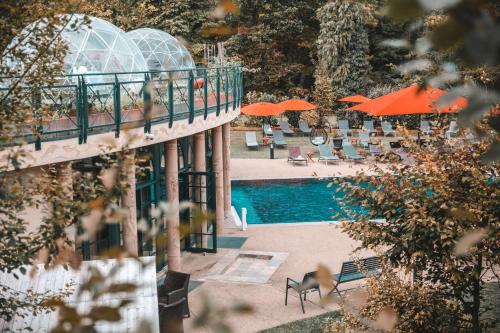 a swimming pool with umbrellas and chairs next to a building at Les Violettes Hotel & Spa in Jungholtz