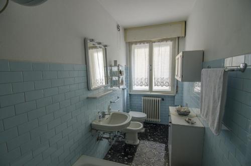 een blauwe en witte badkamer met een wastafel en een toilet bij Accogliente appartamento in Corso Italia in Cortina dʼAmpezzo