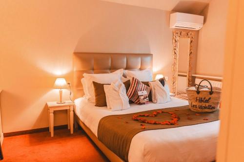 a bedroom with a large bed with white pillows at Les Violettes Hotel & Spa in Jungholtz