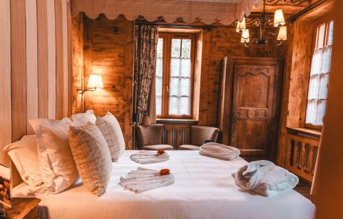 a bedroom with a bed with white sheets and pillows at Les Violettes Hotel & Spa in Jungholtz