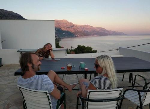 a man and a woman sitting at a table at Hostel Dalmatia in Marusici 