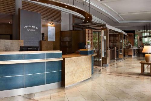 a lobby with a counter in a building at Vienna House by Wyndham Remarque Osnabrück in Osnabrück