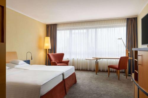 a hotel room with a bed and a desk at Vienna House by Wyndham Remarque Osnabrück in Osnabrück