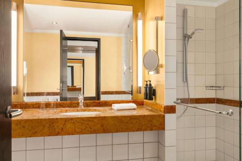 a bathroom with a sink and a mirror at Vienna House by Wyndham Remarque Osnabrück in Osnabrück