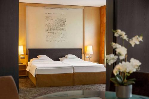 a hotel room with a bed with a picture on the wall at Vienna House by Wyndham Remarque Osnabrück in Osnabrück