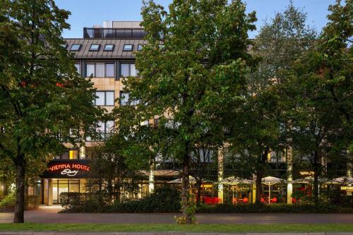 慕尼黑的住宿－Vienna House Easy by Wyndham München，前面有树木的建筑