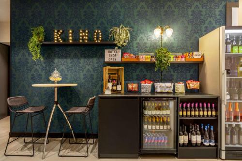 a coffee shop with a counter and a table and chairs at Vienna House Easy by Wyndham München in Munich