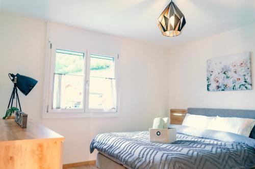 NeirivueにあるGruyère Alpes Appartement 3 chambres BBQ Parkingのベッドルーム1室(ノートパソコン付きのベッド1台付)