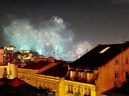 a firework display in the sky over a city at Eddie Rooftop Lisbon center in Lisbon