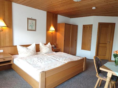 a bedroom with a bed and a desk and a table at Pension Lichtenauer Hof in Thyrnau